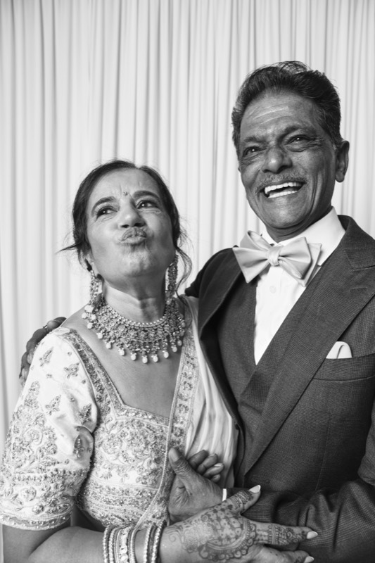 An older couple grin together, she puckers her lips playfully